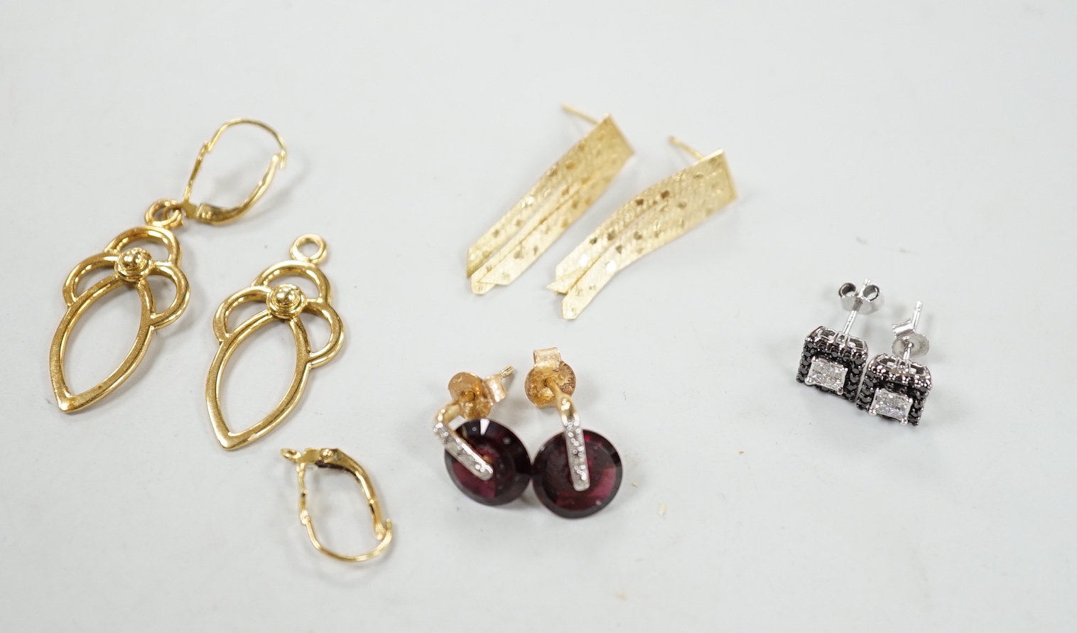 A modern pair of 18ct gold scroll drop earrings, 26mm, 4.7 grams (a.f.) and three other pairs of earrings including 10k, garnet? and diamond and 10k pave set two colour diamond.